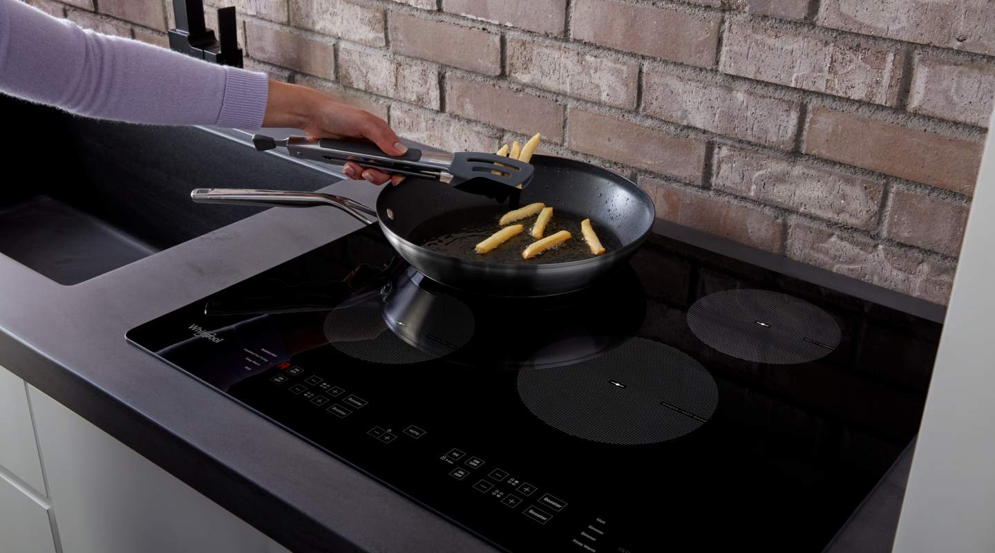 Person frying french fries in frying pan on stovetop