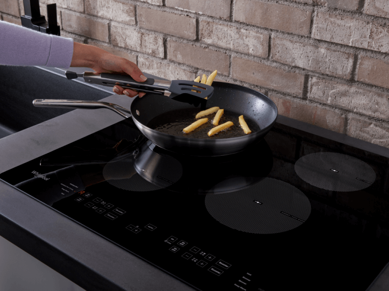 Person frying french fries in frying pan on stovetop