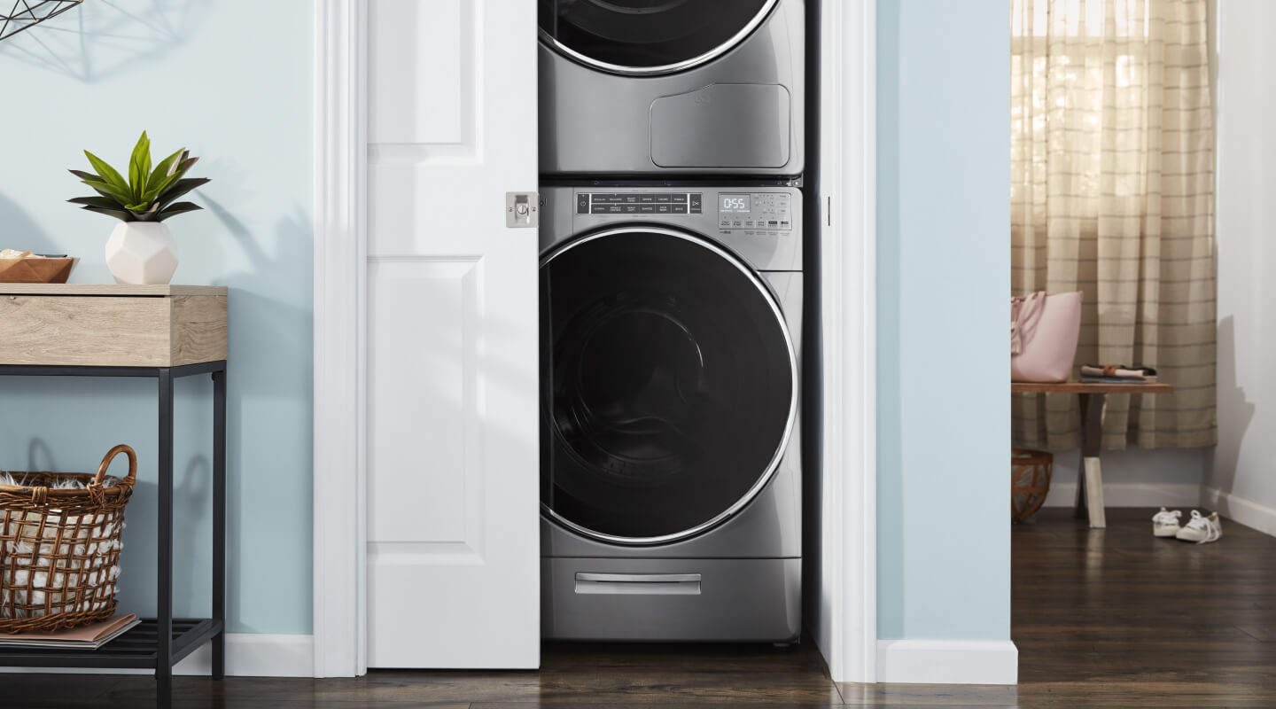 Stackable washer and dryer in a closet with door slightly ajar