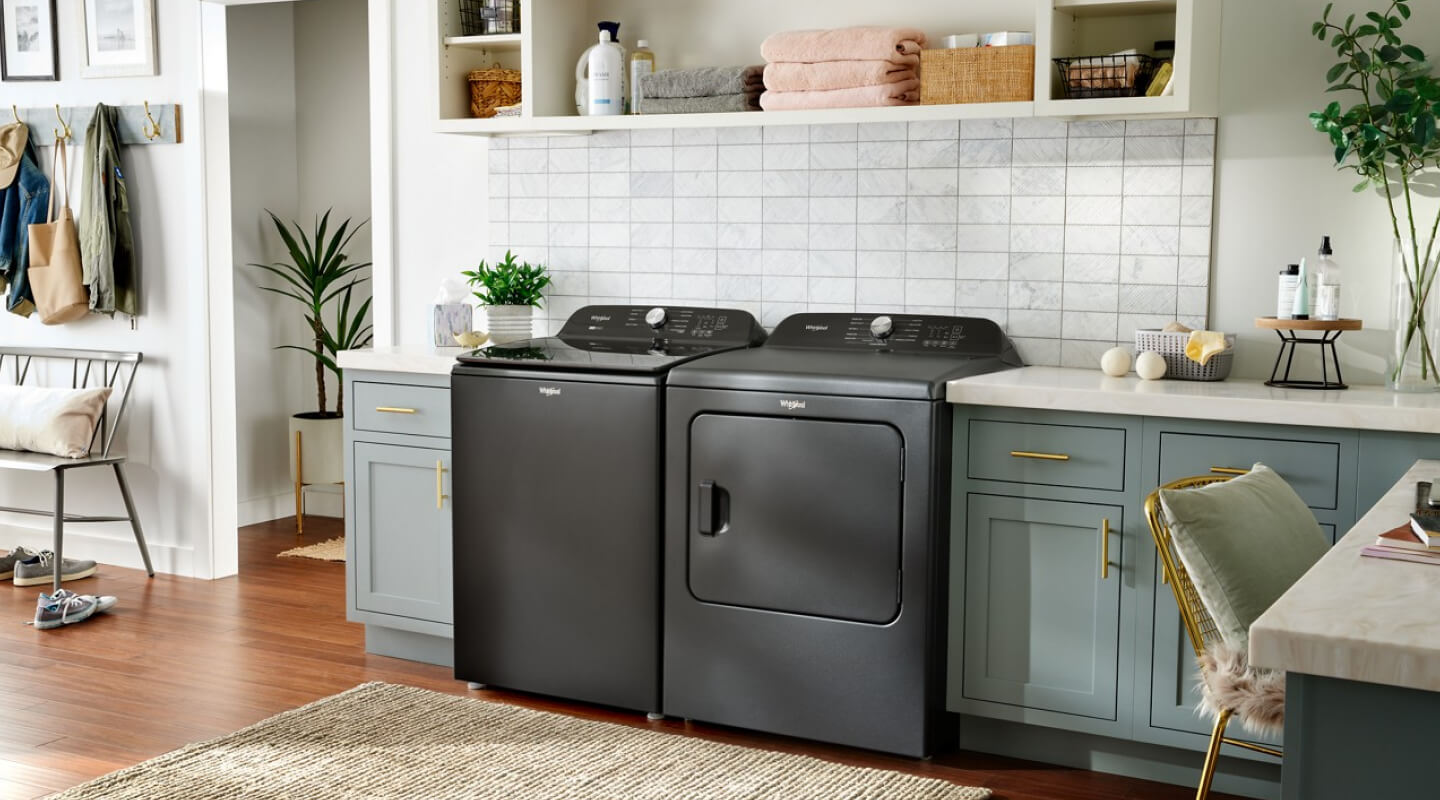 Gray Whirlpool® Top Load Washer and Dryer pair in an open laundry room