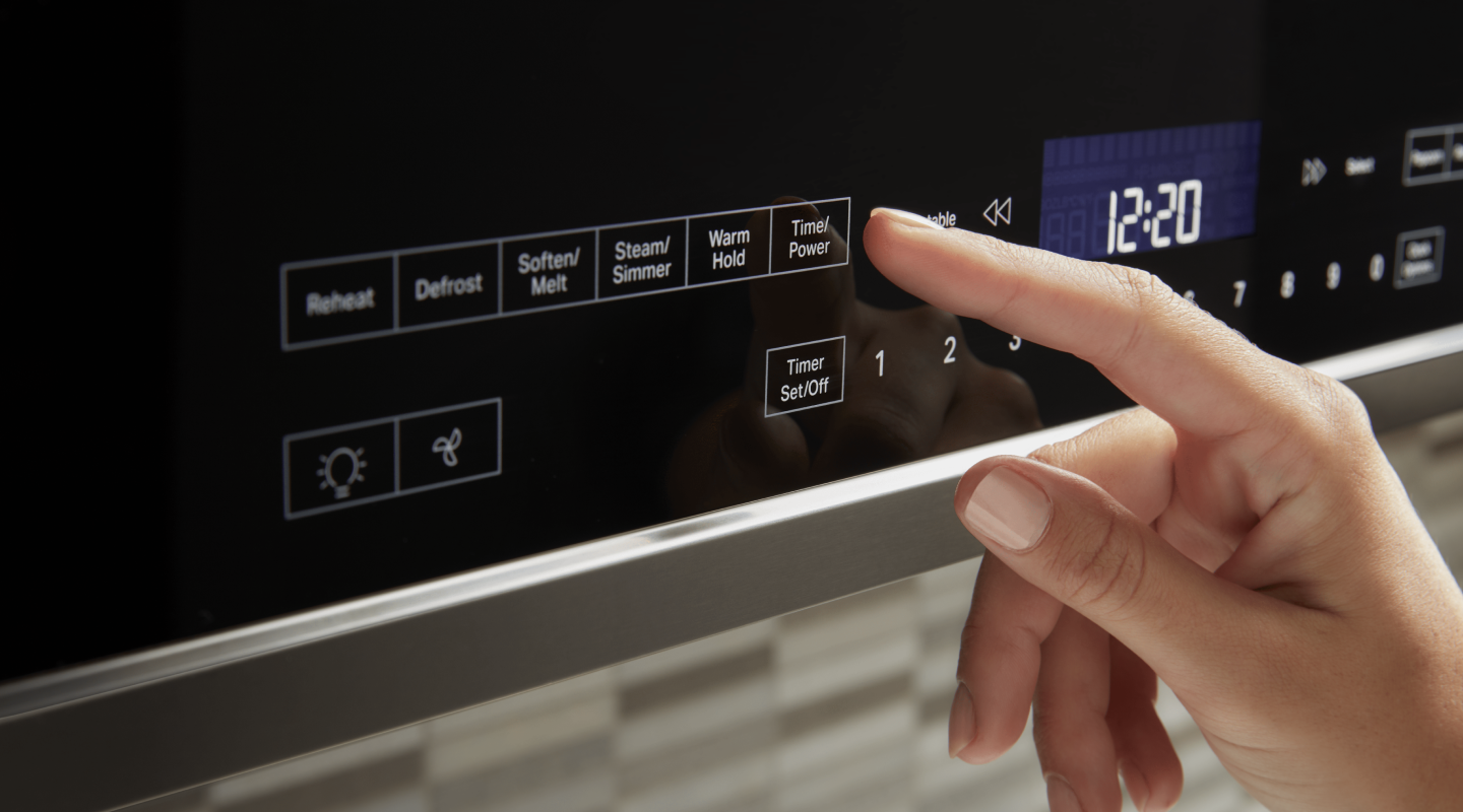 A person selects a microwave setting from a control panel