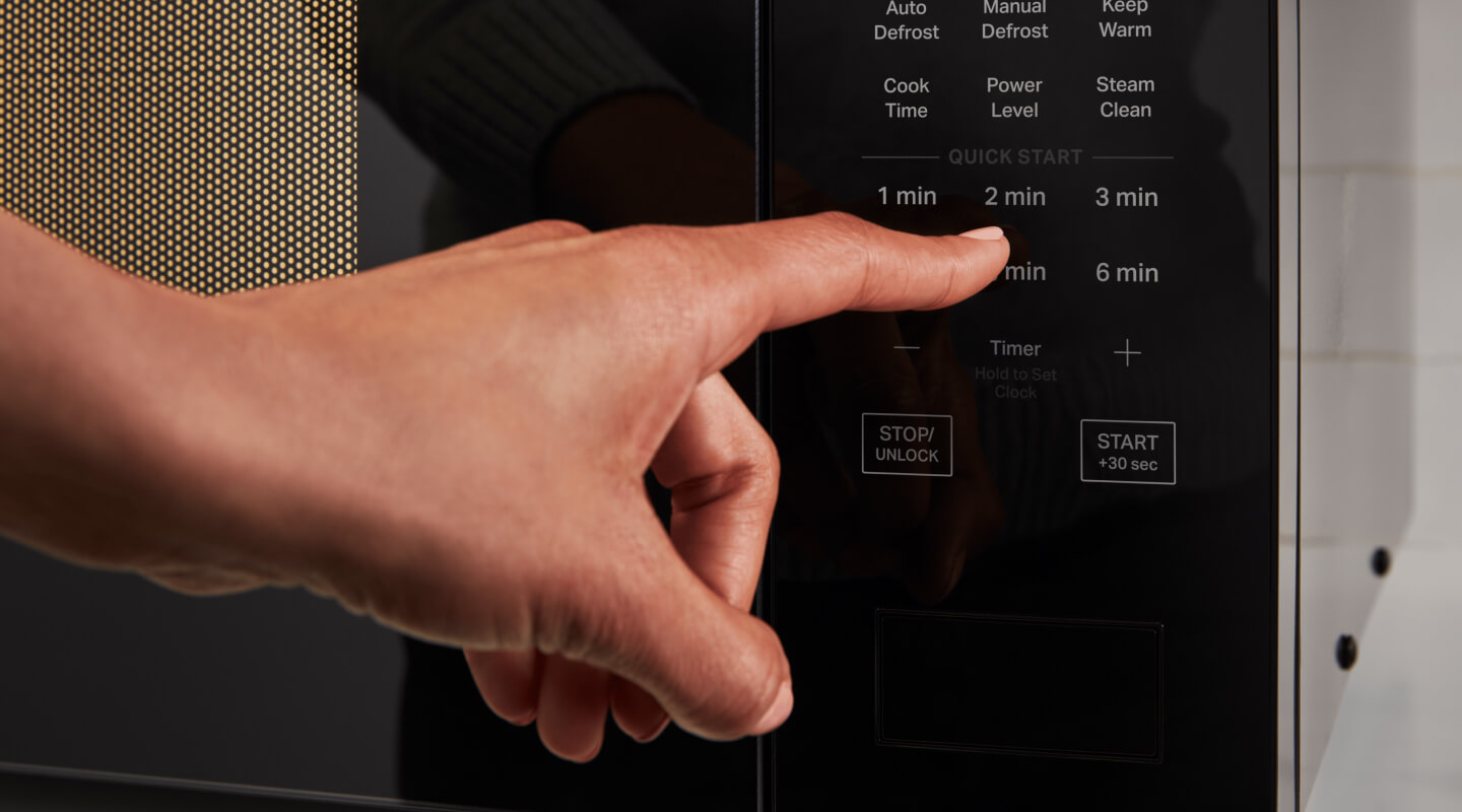 Person selecting a setting on a microwave control panel