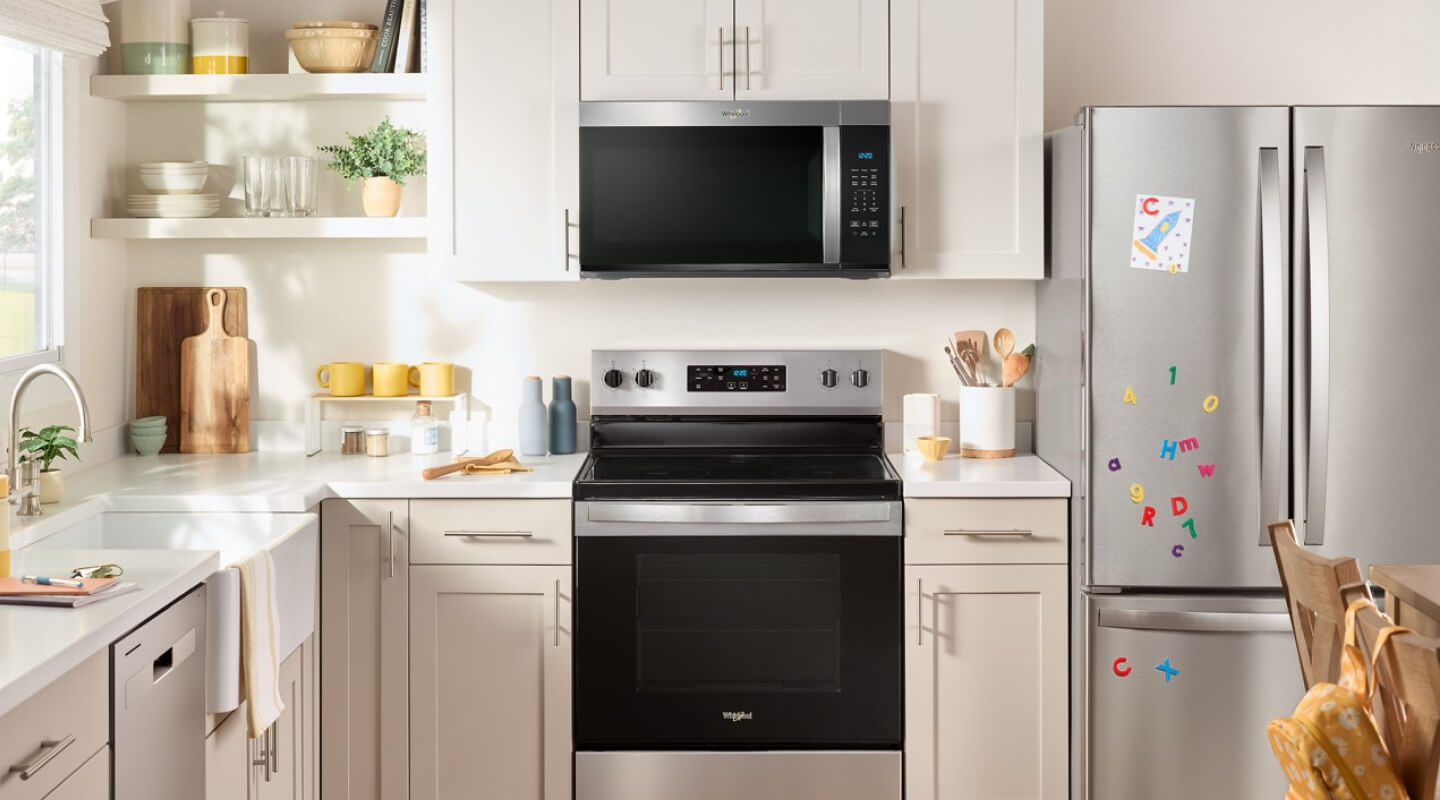 Whirlpool® Over-the-Range Microwave and Electric Range in cream and white cabinetry