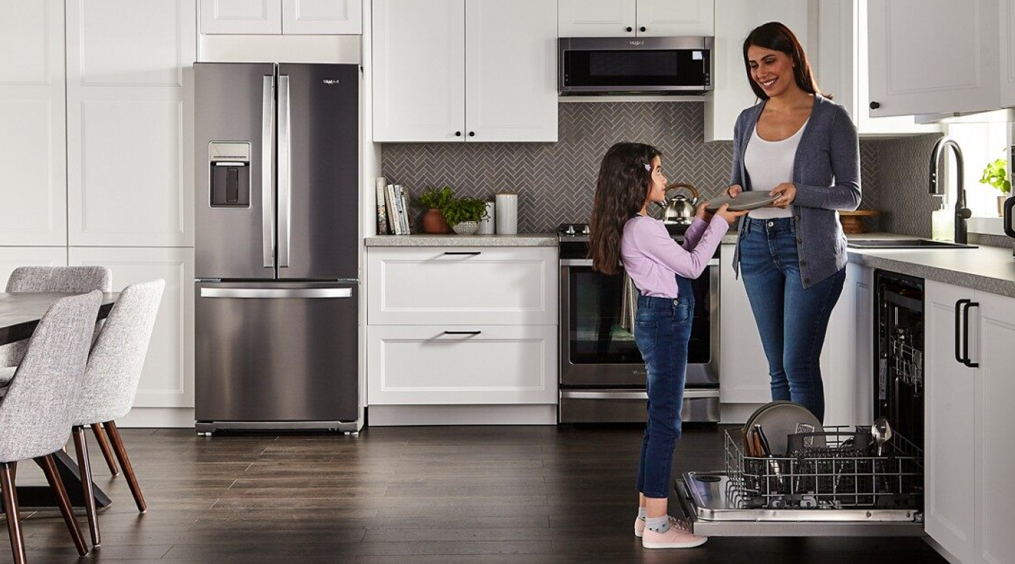 Adult and child unloading a dishwasher