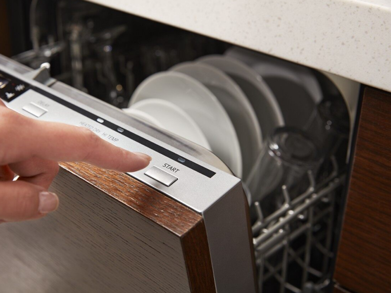 Person selecting a cycle on a dishwasher