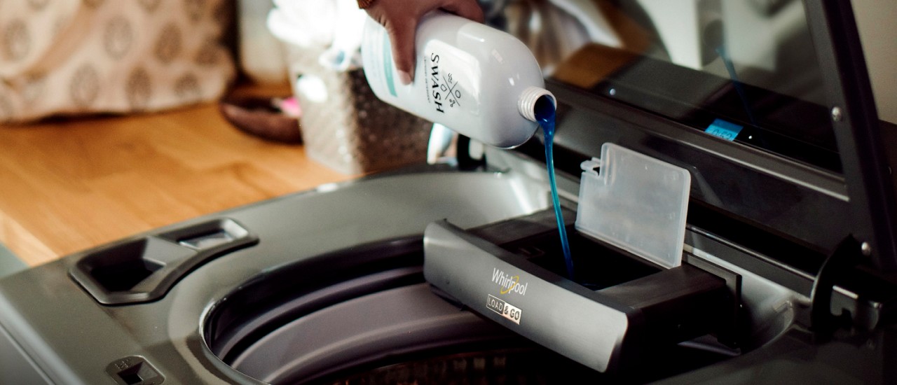 Swash™ Laundry Detergent being poured into a Load & Go™ Dispenser