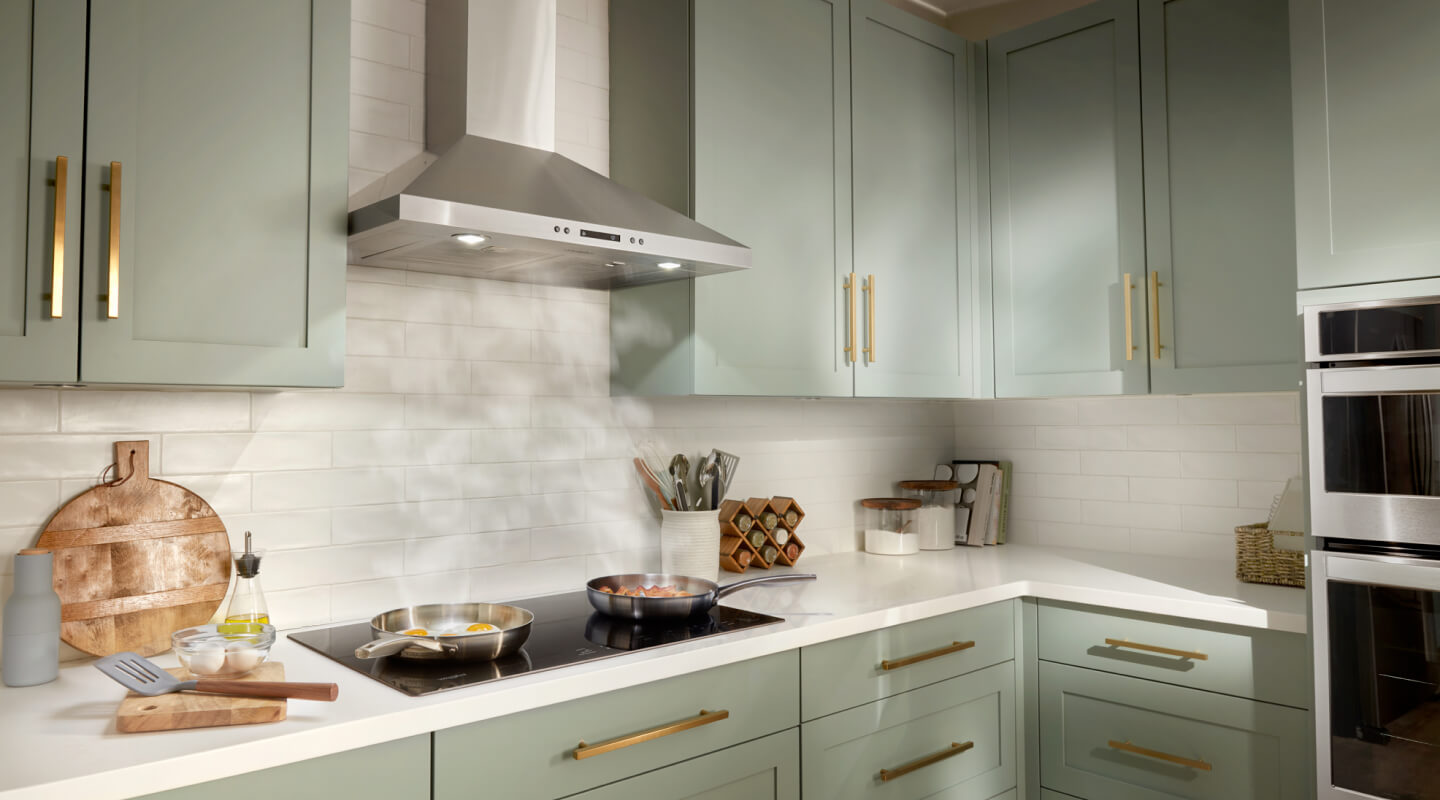 Steam from two pans rising underneath a canopy range hood