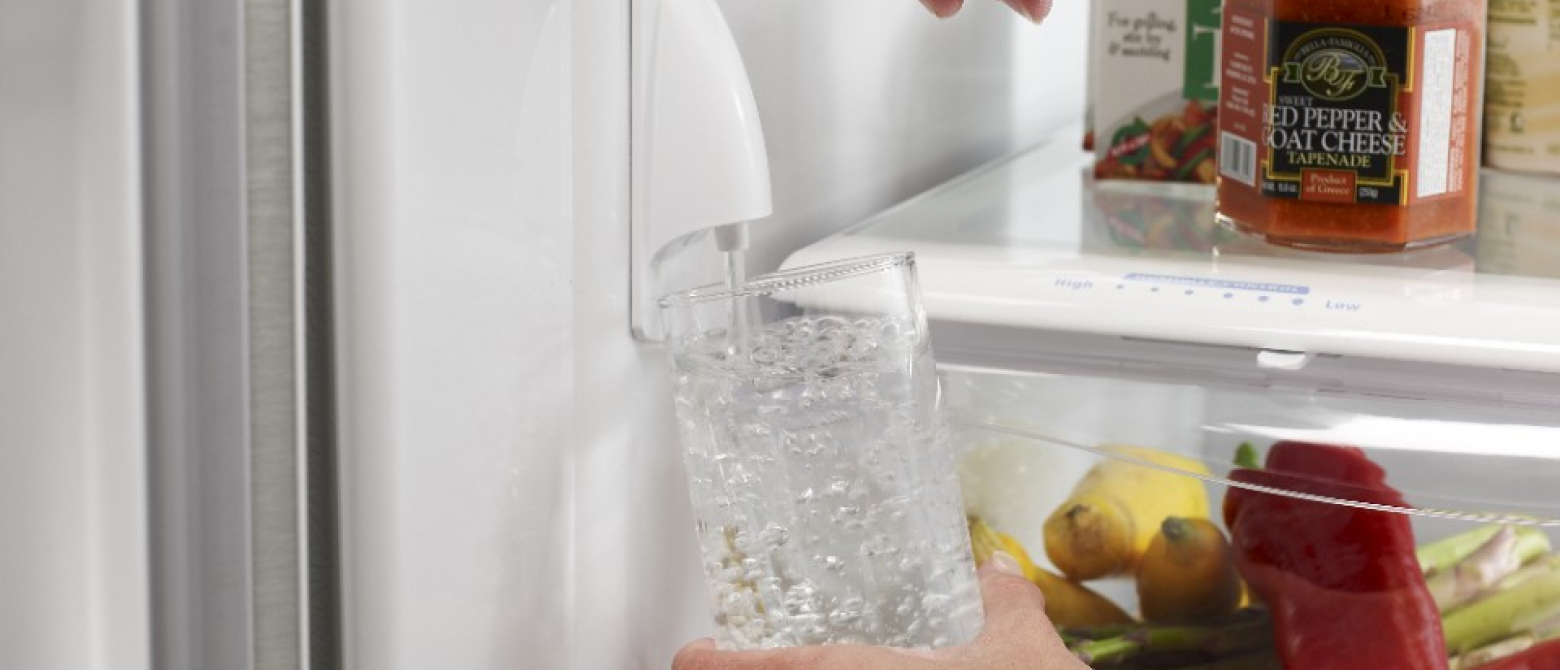 Hand filling up glass with interior water dispenser