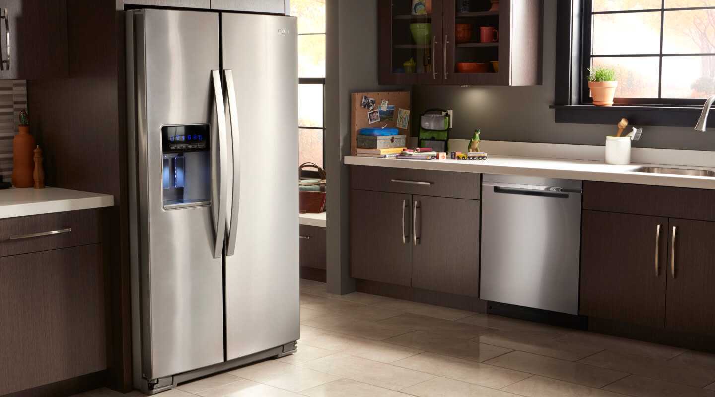 A kitchen with dark cabinetry and stainless steel appliances
