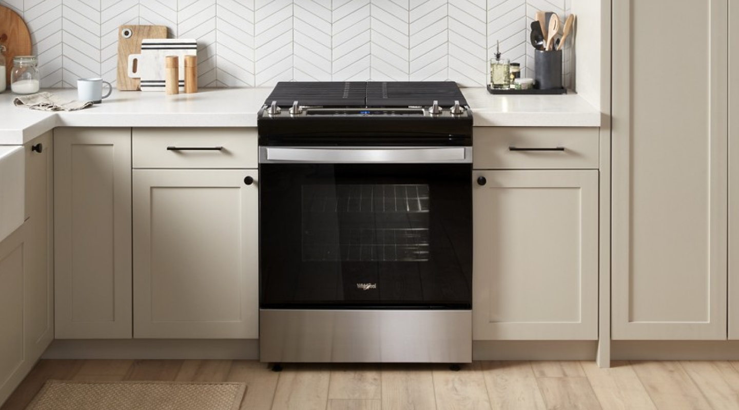 A black slide-in range in a rustic kitchen