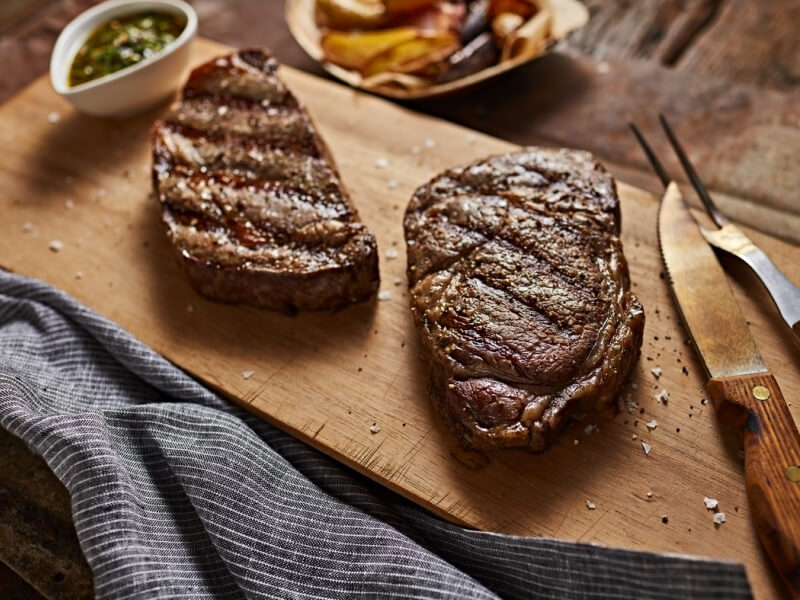 Two steaks on a cutting board