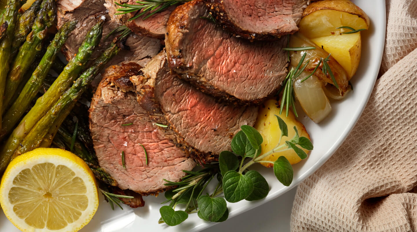 Sliced steak with potatoes and veggies on a plate
