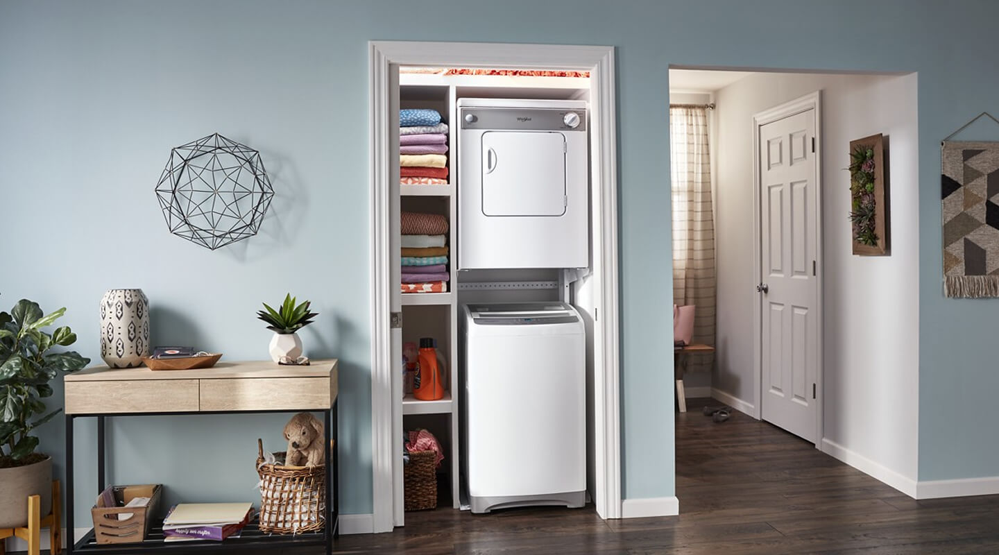 Top load washer and front load dryer mounted in a laundry closet