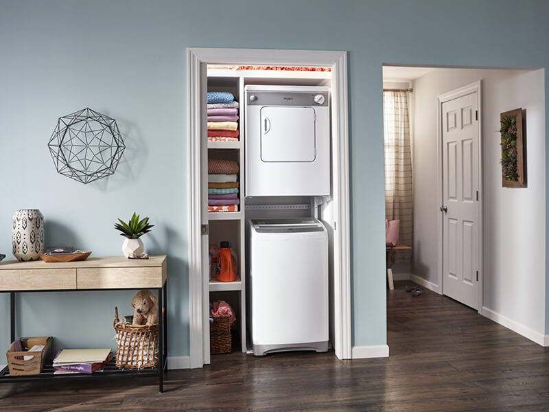 Top load washer and front load dryer mounted in a laundry closet
