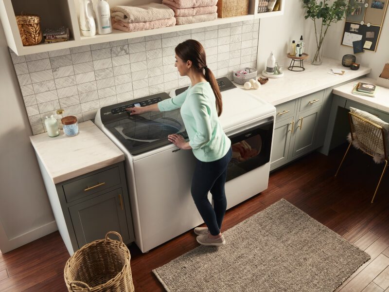 Person making a selection on a washing machine control panel