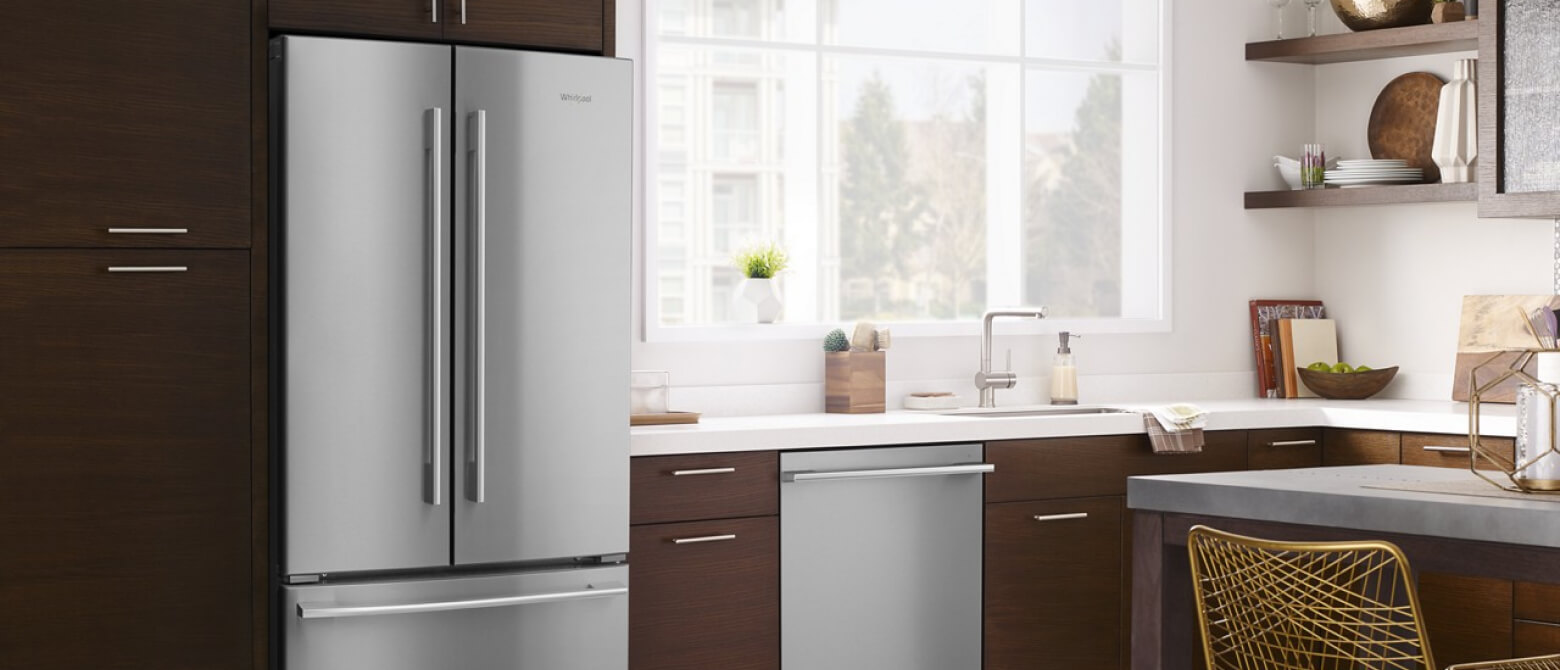 A side-by-side refrigerator in a kitchen with a flush dishwasher