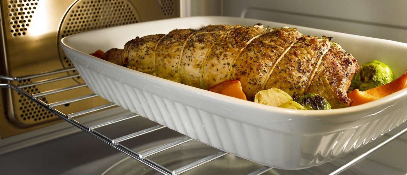 Chicken and vegetables cooking inside a microwave