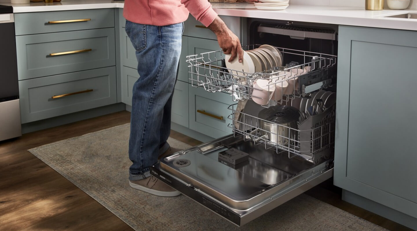 A person loading a dishwasher