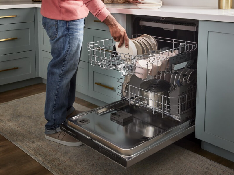 A person loading a dishwasher