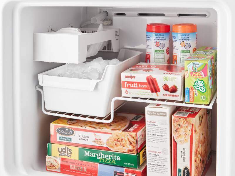 An open freezer packed with frozen food, including popsicles