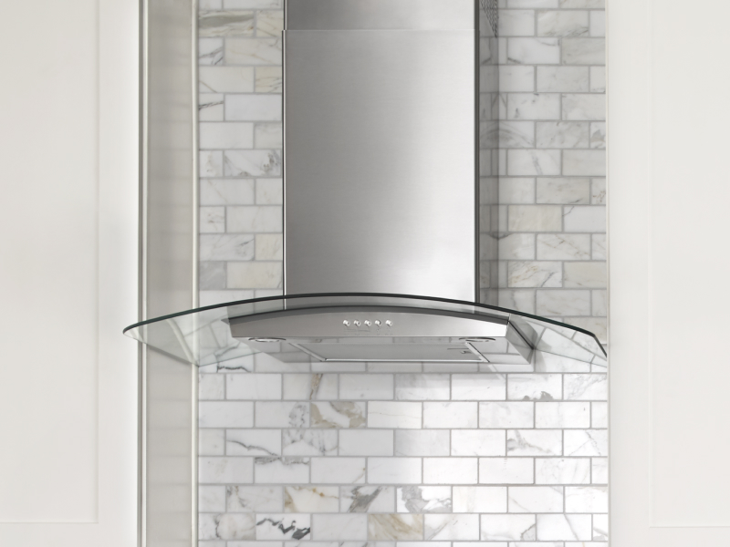 Glass-edged wall-mounted canopy hood between cabinets