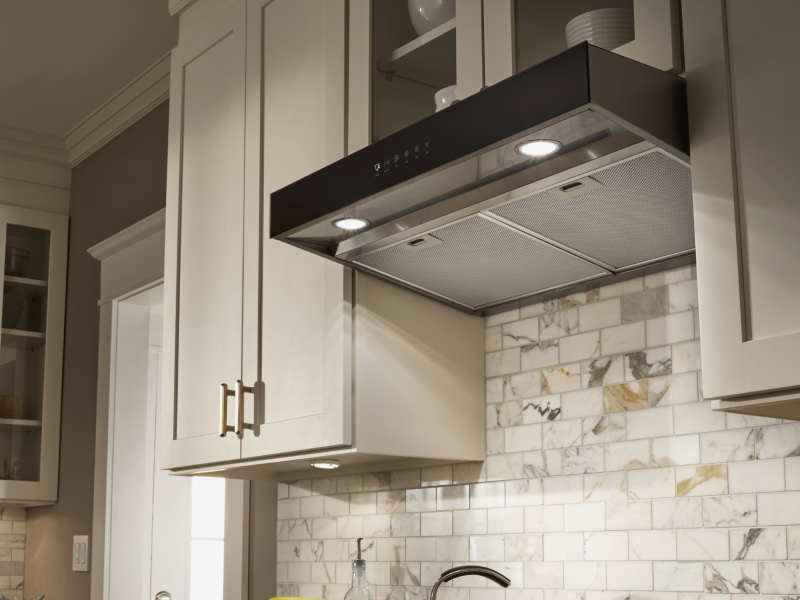 Under-cabinet hood installed beneath modern wood cabinets