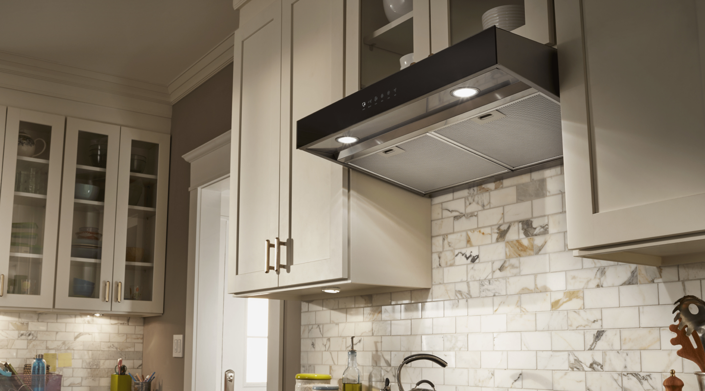 Under-cabinet hood installed beneath modern wood cabinets