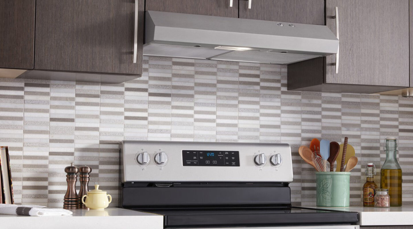 A Whirlpool® Under Cabinet Range Hood and Range in a kitchen