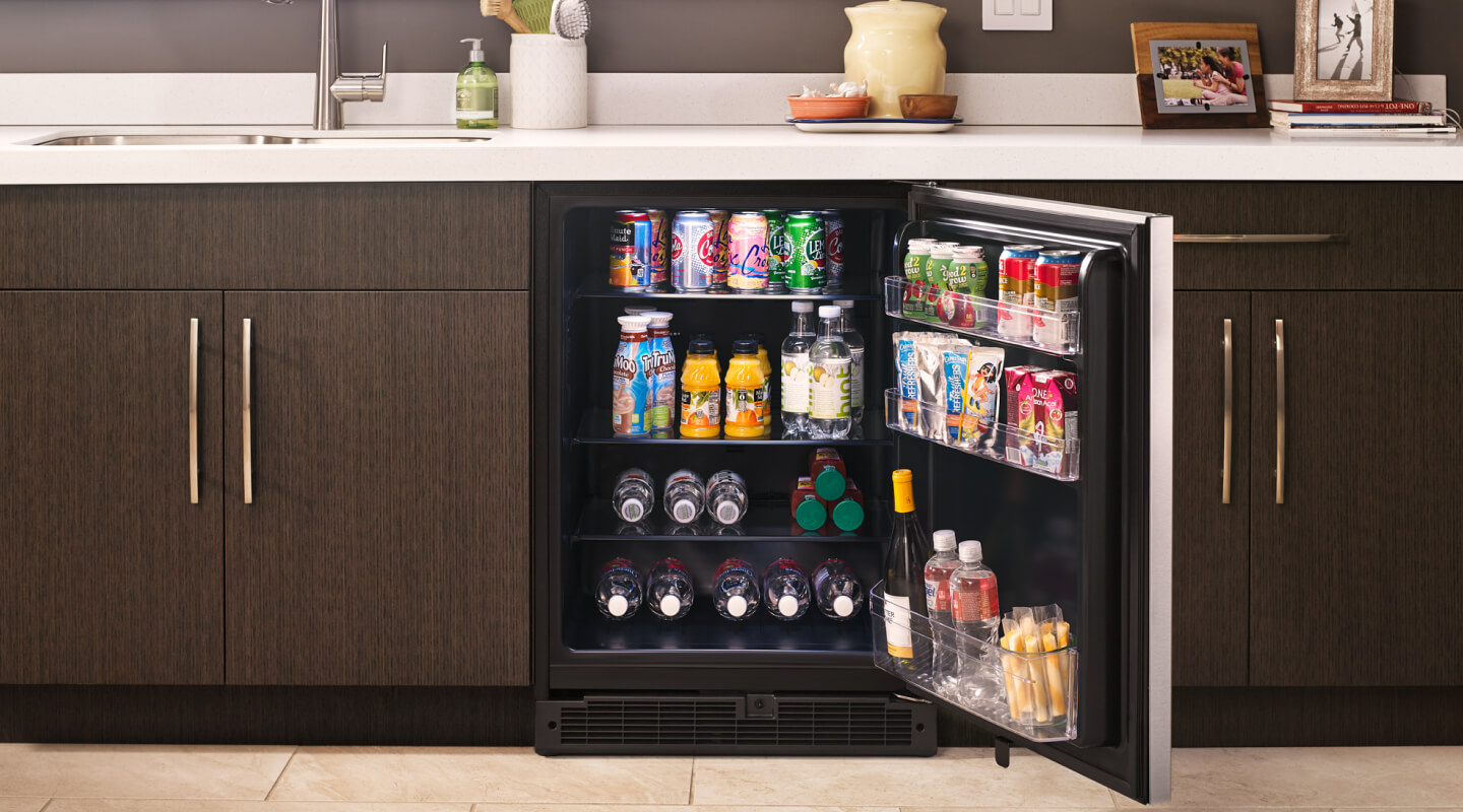  Fully stocked open undercounter refrigerator in a kitchen