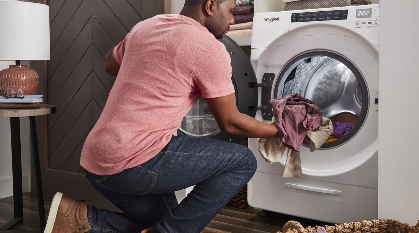 Person loading laundry in a Whirlpool® Dryer