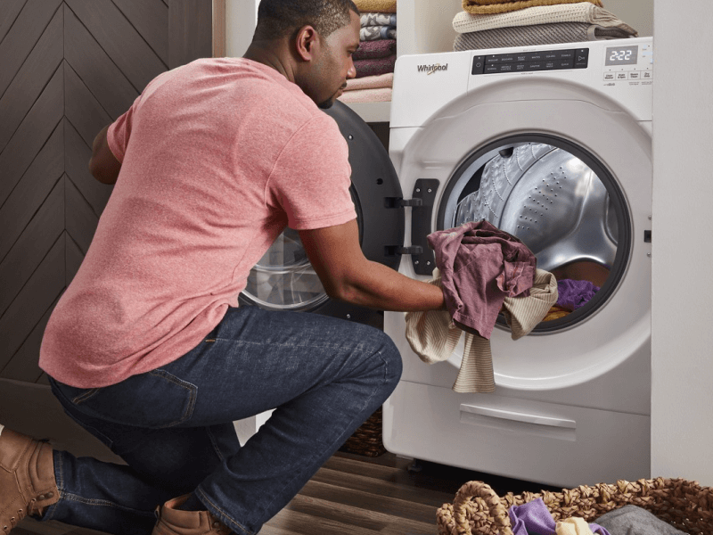 Person loading laundry in a Whirlpool® Dryer