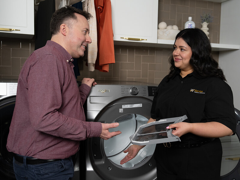 A technician helping a man with his dryer