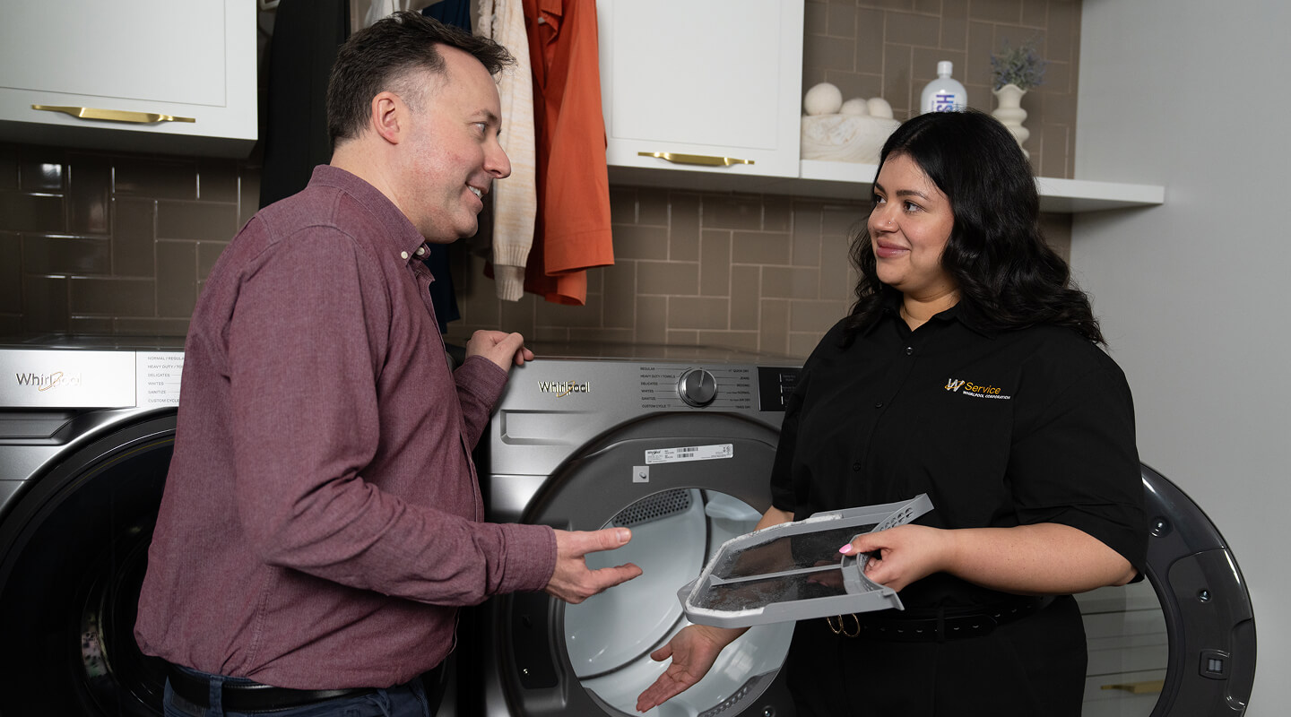 A technician helping a man with his dryer