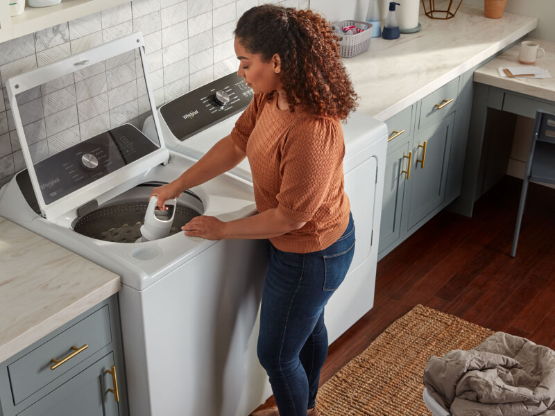 A person adjusting a removable agitator in their Whirlpool® Washer