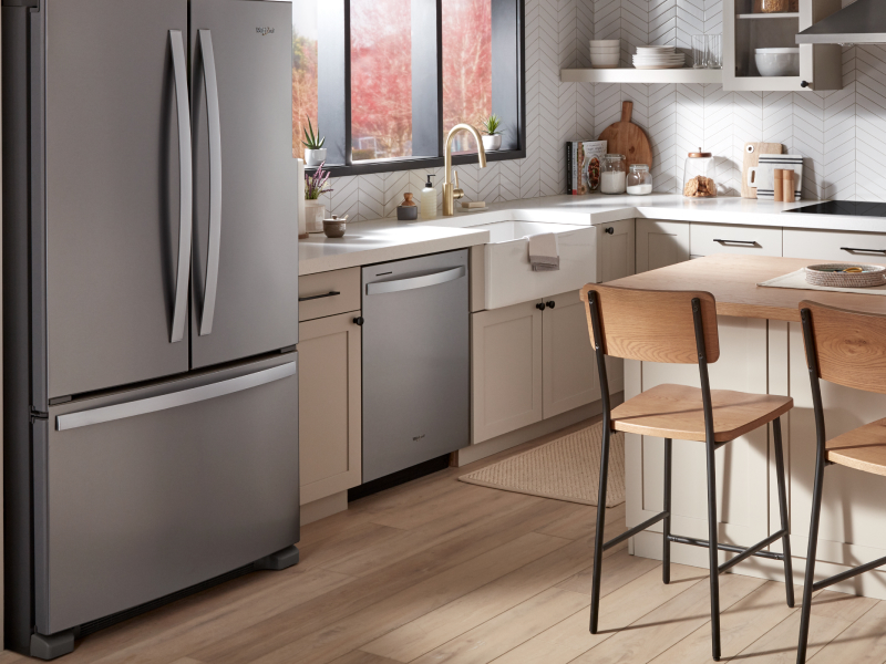 A Whirlpool® dishwasher and appliances in a kitchen with an island.