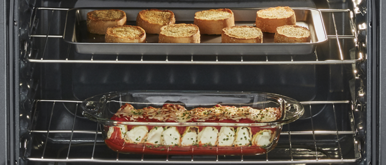 Garlic bread and manicotti inside an oven