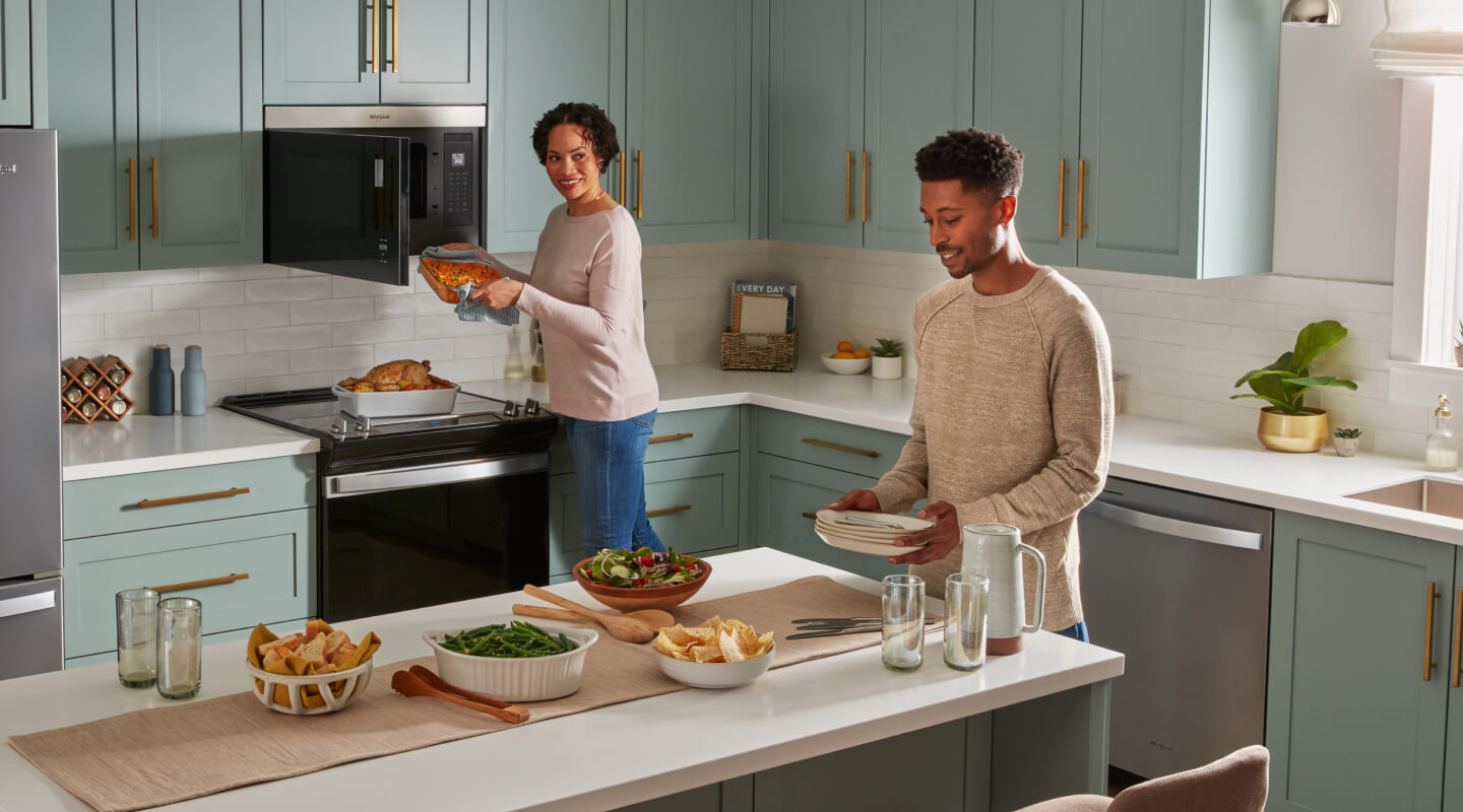 People preparing food in an open kitchen with blue cabinetry 