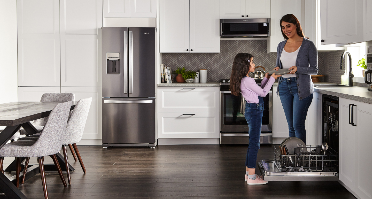 A mother and daughter unloading the dishwasher