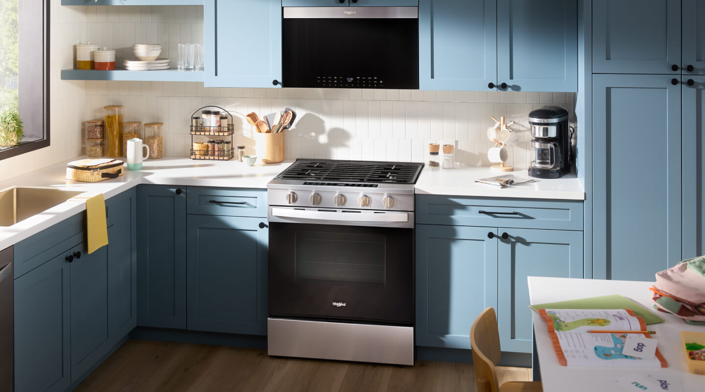 Kitchen with blue cabinetry and stainless steel Whirlpool® appliances