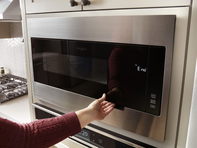 Hand opening a microwave door