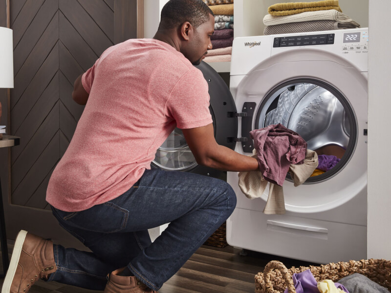 A person loading laundry into a Whirlpool® All-In-One Washer Dryer Combo