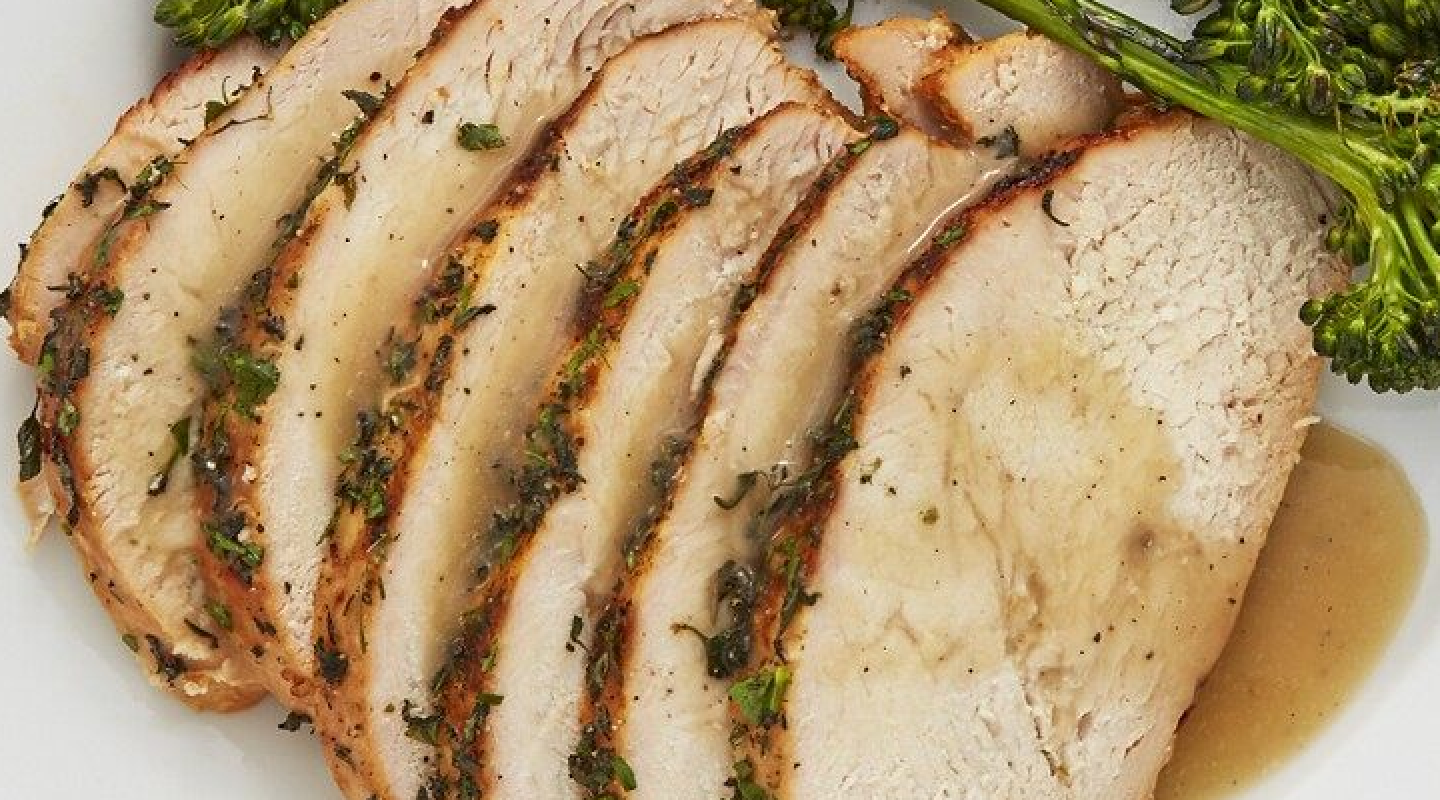 Sliced turkey with gravy garnished with herbs