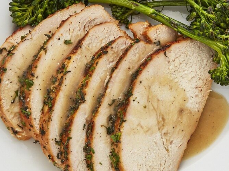 Sliced turkey with gravy garnished with herbs