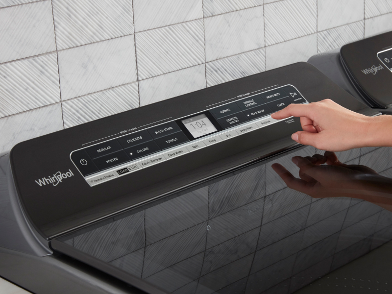A person selects a laundry cycle from a touchpad