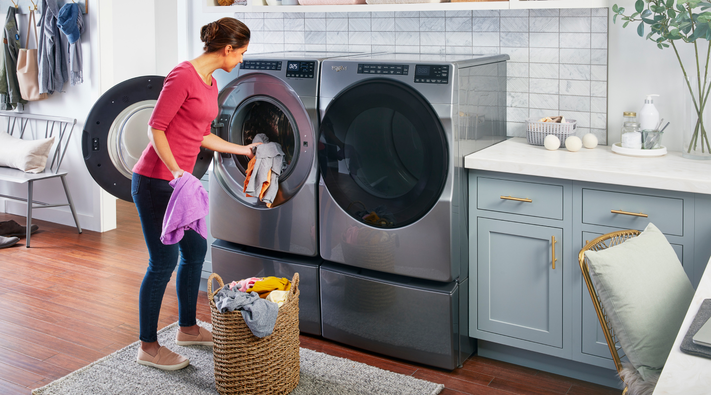 A person putting laundry into the washer