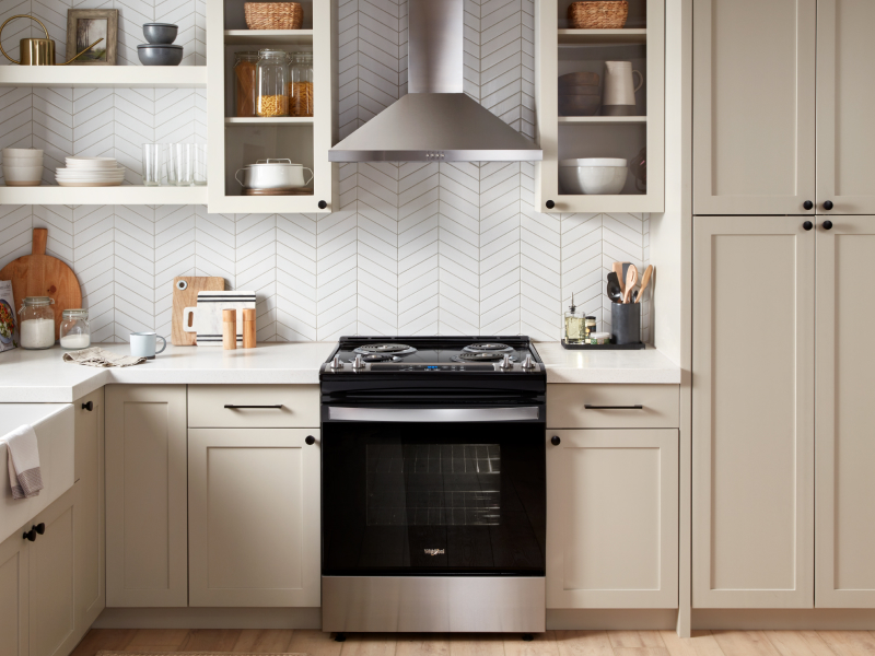 Stainless steel range hood above a Whirlpool® range