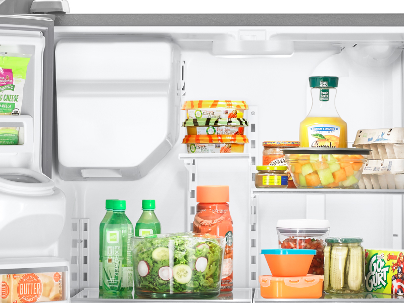 Various food items on the shelves and in the bins of a refrigerator