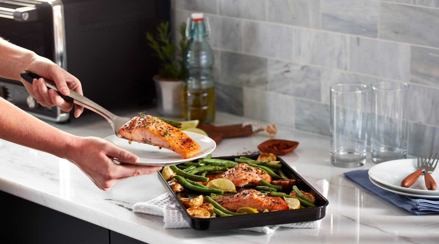 Person putting fish on a grill pan