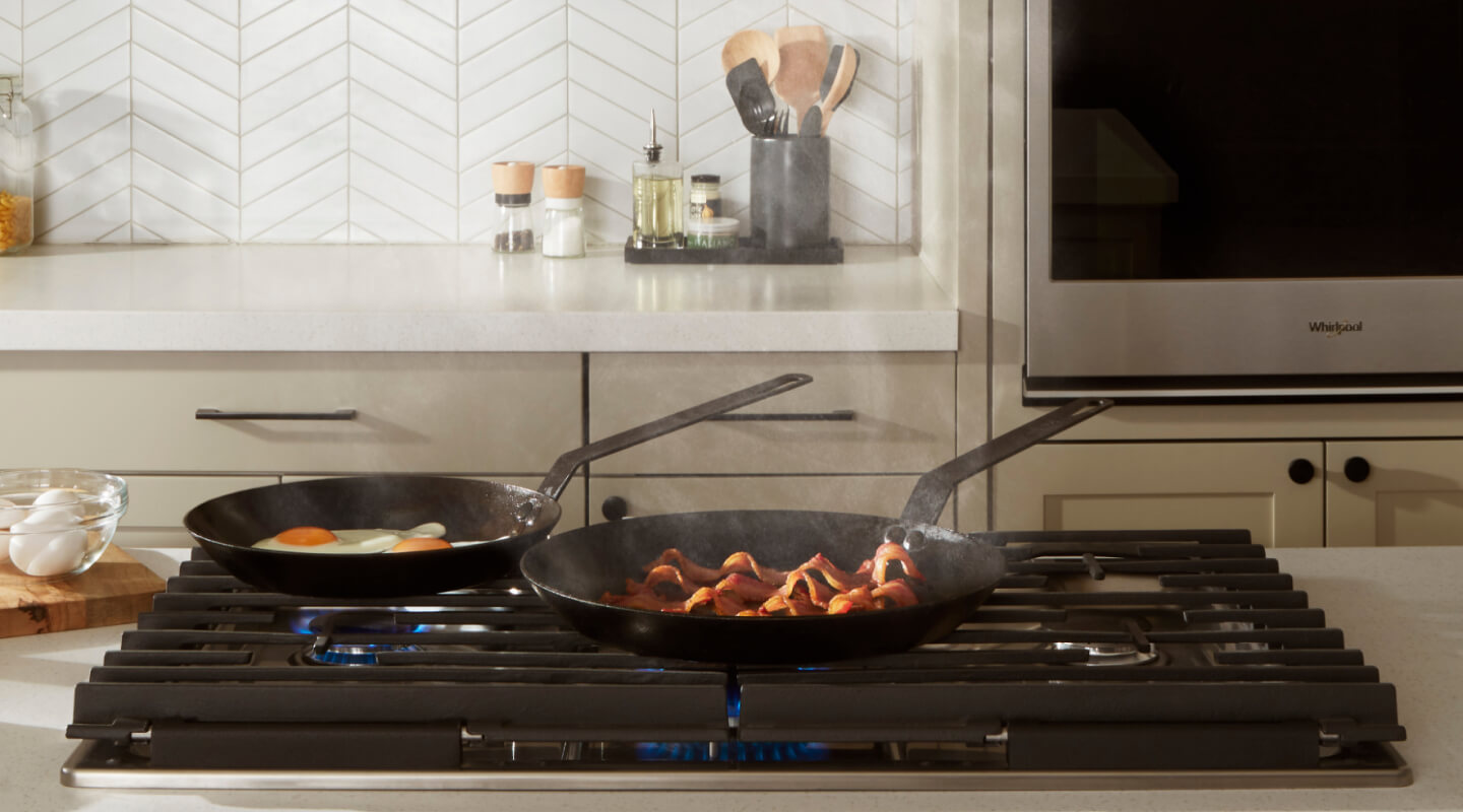 Pans cooking food on a Whirlpool® Cooktop