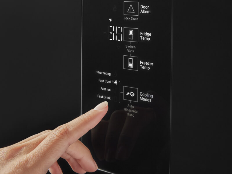 A person selecting the freezer temperature